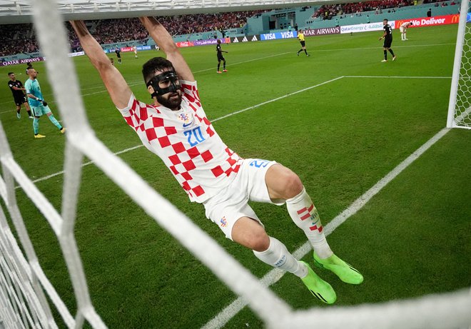 Hrvaški igralec Joško Gvardiol visi s prečke gola. FOTO: Hannah Mckay, Reuters
