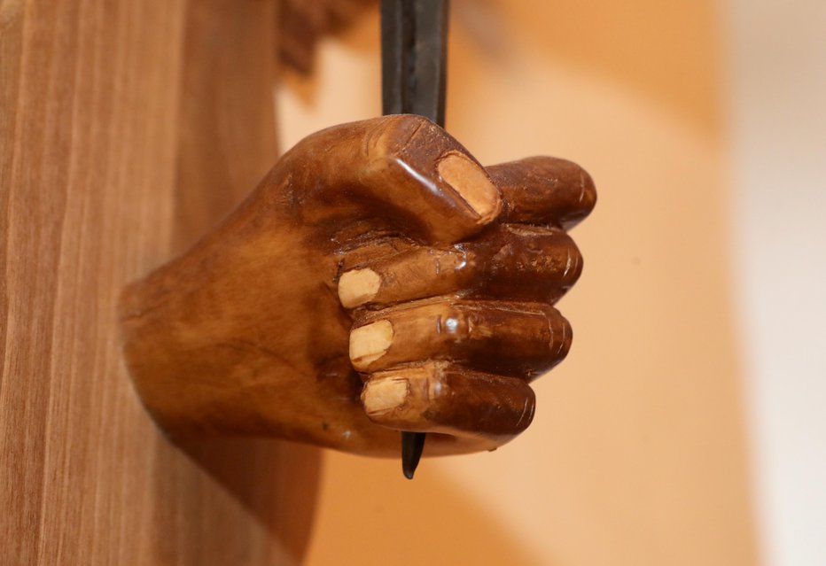 Fotografija: Roka, ki drži osrednji žebelj, je iz lipovega lesa. Foto: Dejan Javornik
