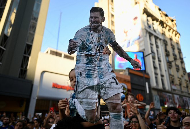 Argentinski navijači slavijo po zmagi s podobo Messija. FOTO: Martin Villar, Reuters

