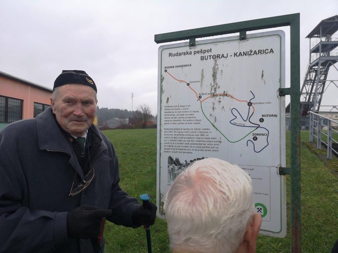 Janko Škarja pred tablo pešpoti iz Butoraja v Kanižarico. Po njej so pred prihodom avtobusa leta 1985 tri kilometre hodili peš.
