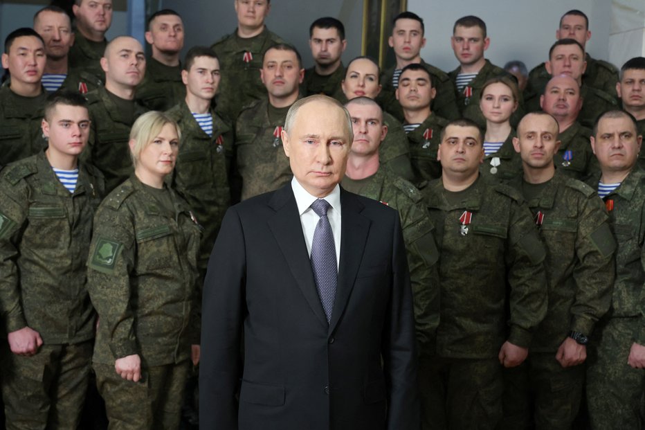 Fotografija: Ruski predsednik Vladimir Putin je na letnem novoletnem nagovoru narodu na poveljstvu južnega vojaškega okrožja v Rostovu na Donu v Rusiji uporabil statiste, ki so igrali vojake. Javnosti je bilo zapisano, da naj bi šlo za vojake, ki se borijo v Ukrajini. FOTO: Sputnik Via Reuters
