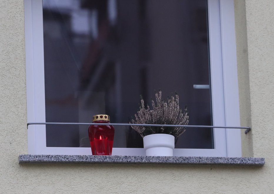 Fotografija: Na polici okna domače hiše, kjer se je zgodila družinska tragedija, je včeraj gorela svečka. FOTO: Dejan Javornik
