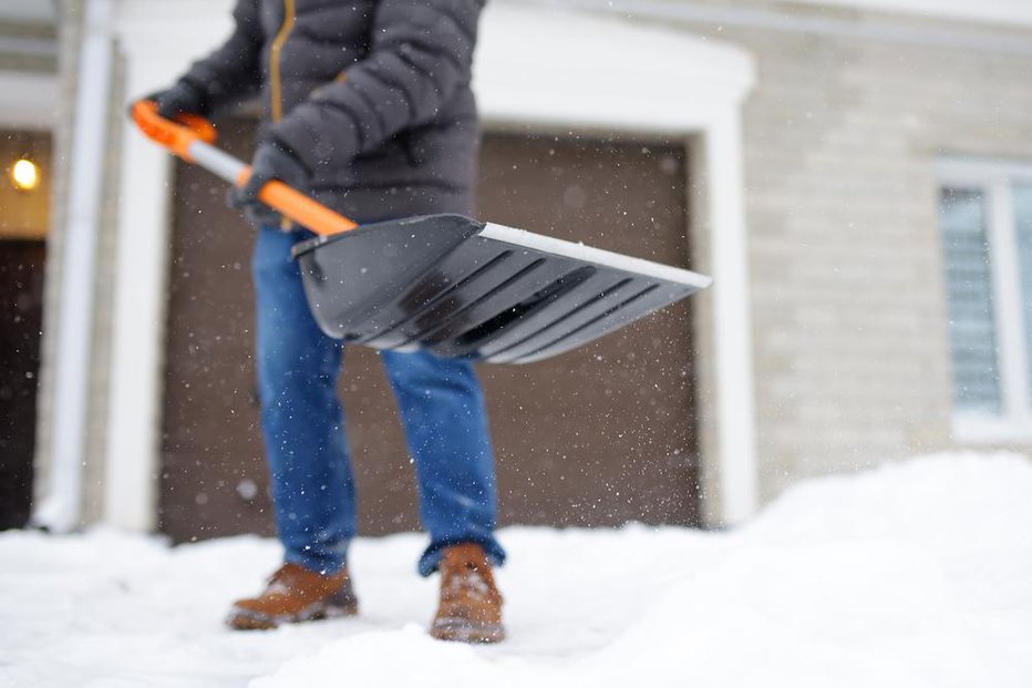 Fotografija: Tudi če se boste snega hoteli znebiti čim hitreje, na lopato ne nalagajte prevelike teže. FOTO: Arhiv Polet/ Shutterstock
