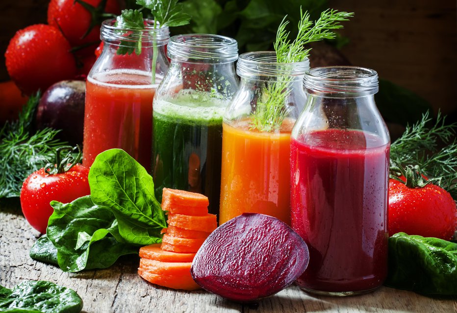 Fotografija: Four kind of vegetable juices: red, burgundy, orange, green, in small glass bottles, fresh vegetables and herbs, vintage wooden background, selective focus