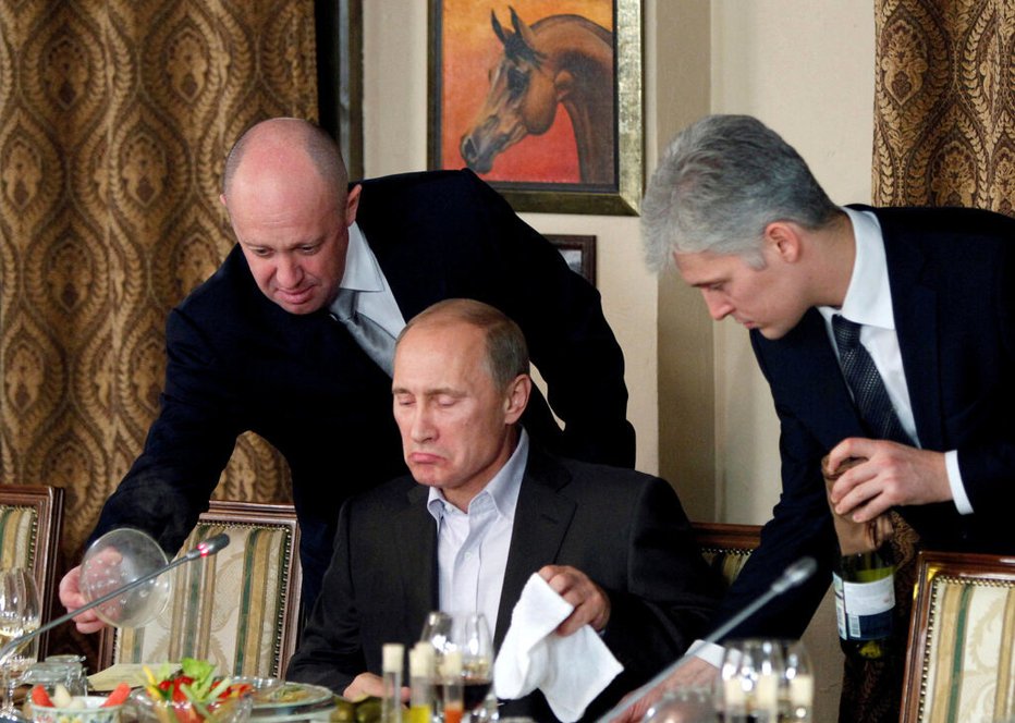 Fotografija: Jevgenij Prigožin (levo), lastnik Wagnerja, pomaga Vladimirju Putinu med eno od uradnih večerij v Kremlju. Foto: Miša Japaridze/REUTERS​

