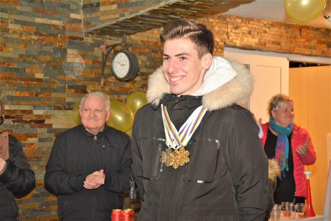 Nasmejan s svojimi tremi medaljami, v ozadju dedi Feliks Zajc
