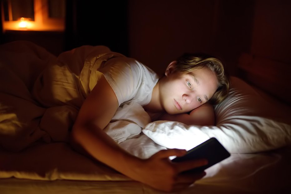 Fotografija: Nikar s telefonom v posteljo, raje z dobro knjigo. FOTO: Getty Images/iStockphoto
