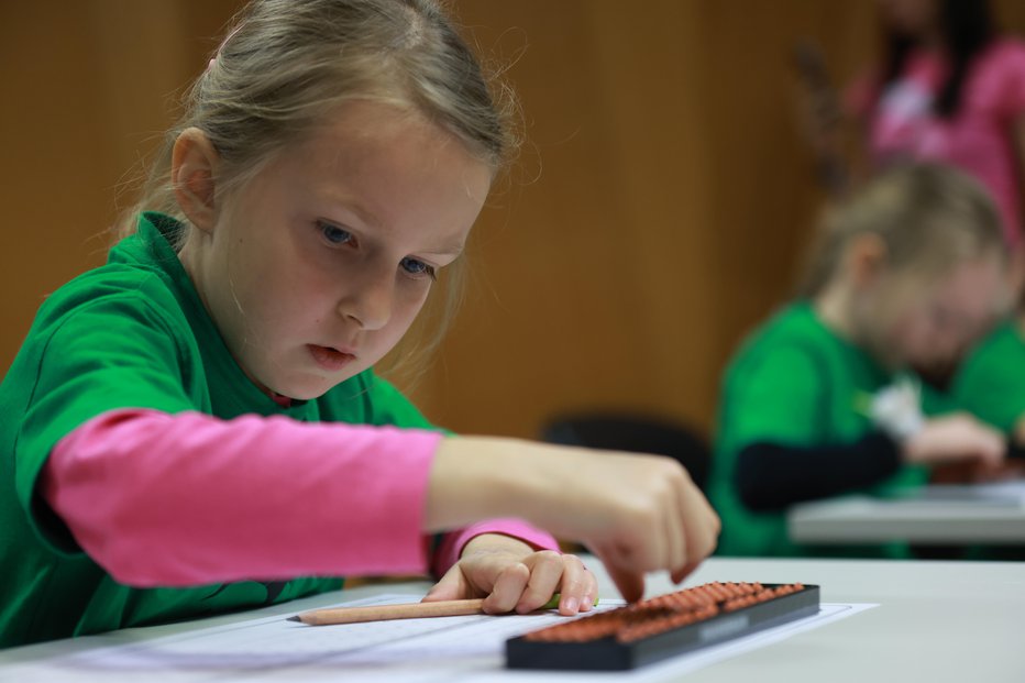 Fotografija: Mali BOBki, kot ljubkovalno kličejo otroke v programu, rešujejo matematične naloge z abakom, enostavnim mehanskim računalom.