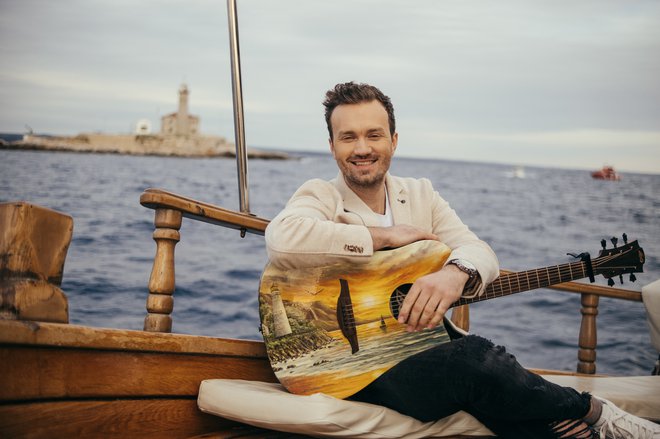 Ponosen je na svojo unikatno kitaro, ki jo je poslikala Neža Erjavec. FOTOGRAFIJI: ROK BREZNIK