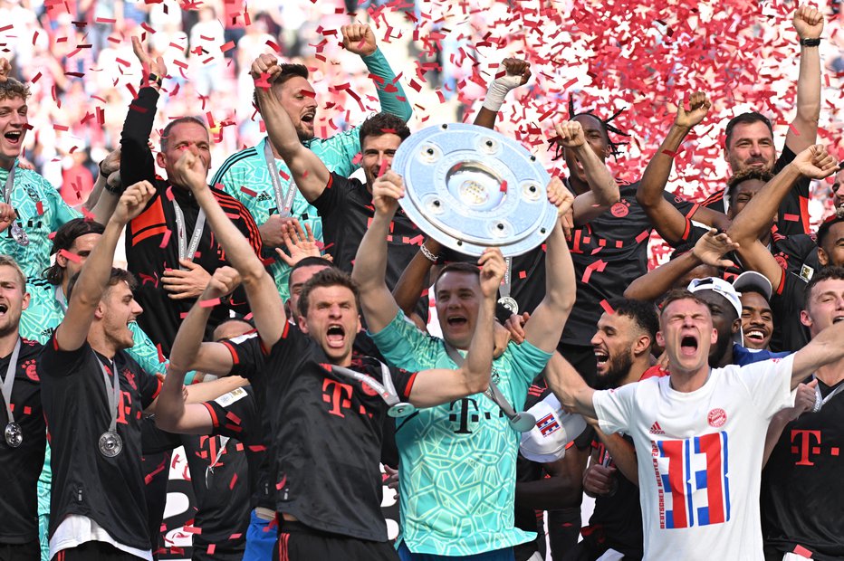 Fotografija: Thomas Müller (levo ob vratarju Manuelu Neuerju s krožnikom) se je veselil že rekordnega 12. naslova nemškega prvaka. FOTO: Benjamin Westhoff/Reuters