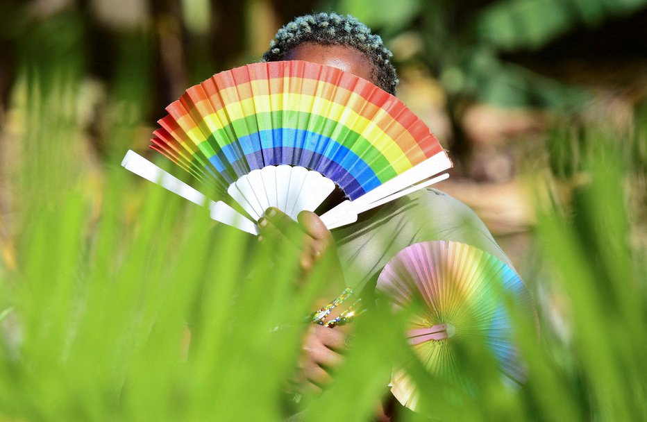 Fotografija: Pripadnica ugandske skupnosti LGBTQ z mavrično pahljačo FOTO: Abubaker Lubova/Reuters
