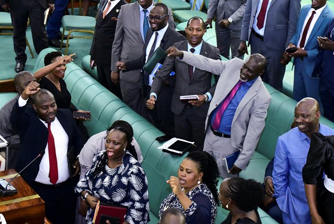 Poslanci so takole slavili sprejem zakona v parlamentu. FOTO: Abubaker Lubova/Reuters