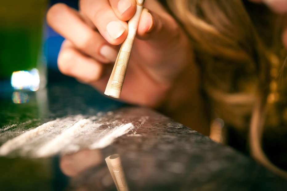 Fotografija: Dekle z bankovcem vsrkava kokain. FOTO: Getty Images/iStockphoto