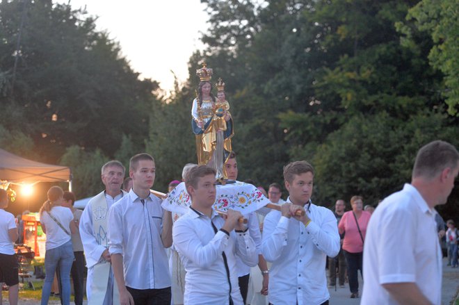 Fantje so pred cerkev prinesli kip Marije. FOTO: Drago Perko