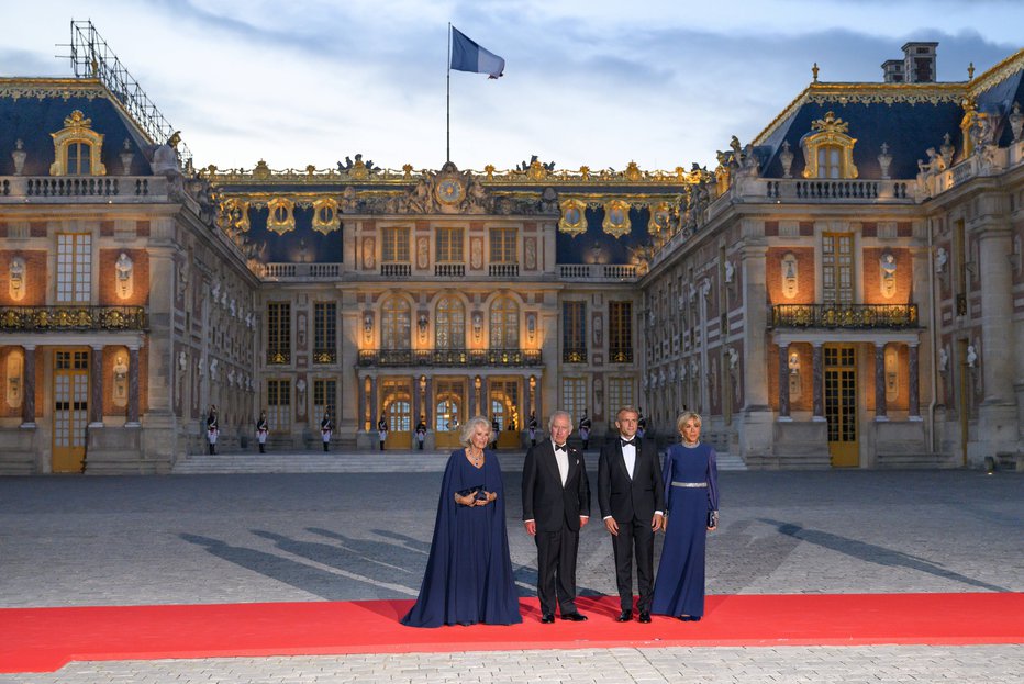 Fotografija: Prvi dami pred palačo

Obe sta oblekli temno modro: kraljica Camilla je v Diorjevi obleki z ogrinjalom kljubovala vetru ob svojem izbrancu kralju Karlu III., Brigitte Macron pa je v obleki hiše Louis Vuitton navdušila zraven moža, predsednika Emmanuela Macrona.