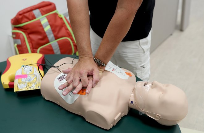 Med oživljanjem sledimo navodilom defibrilatorja. FOTO: Blaž Samec/Delo
