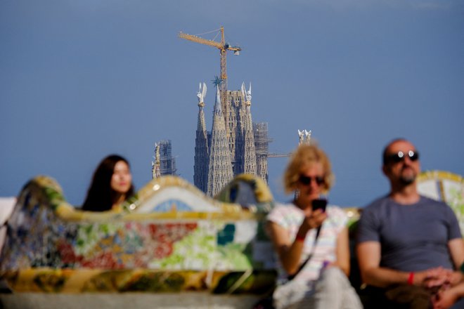 Obiskovalci znanega barcelonskega parka Guell s Sagrado Familio v ozadju FOTO: Darrin Zammit Lupi/Reuters