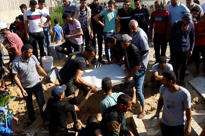 Med pokopom palestinske družine. FOTO: Ibraheem Abu Mustafa Reuters