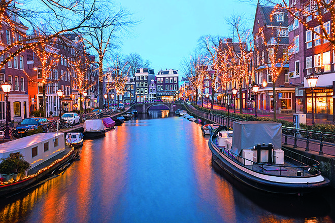 Z ladjico po kanalih Amsterdama. FOTO: Depositphotos
