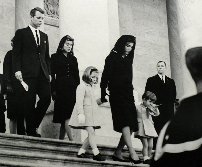 Brat pokojnega predsednika in pravosodni minister Robert F. Kennedy in njegova sestra Patricia spremljata Jackovo hčer Caroline, vdovo Jackie in sina Johna mlajšega na dan pogreba. FOTO: Abbie Rowe/JFK Library/Reuters
