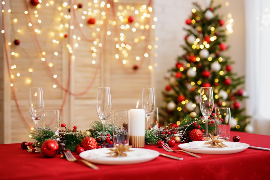 Fotografija: Decorated table with plates and glasses for christmas dinner in living room