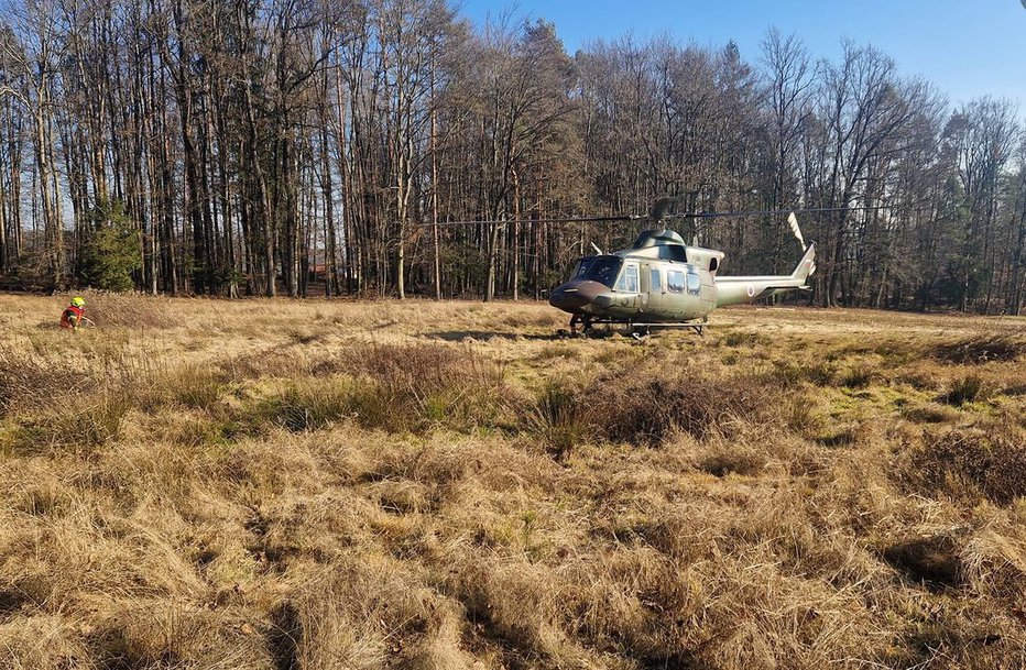 Fotografija: Gasilci so pomagali pri prenosu poškodovane osebe do helikopterja. FOTO: Gasilska Enota Lokavec