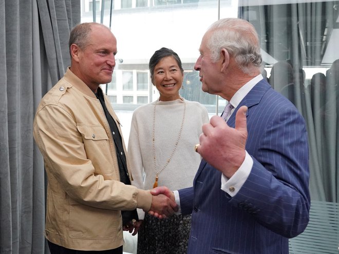 Kralj Charles III med poogovorom z igralcem Woodyjem Harrelsonom in njegovo ženo Lauro Louie v Londonu maja 2023. FOTO: Pool Reuters