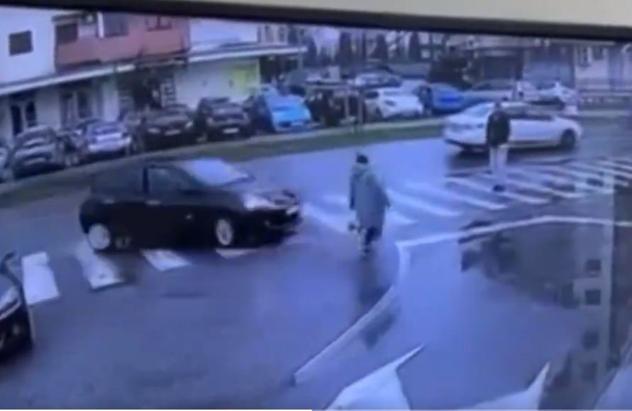 Fotografija: Na posnetku je videti, kako avto zavije desno po cestišču in zbije žensko, ki je hodila tik ob prehodu za pešce. Trčil je vanjo, zato je padla na pločnik. FOTO: Zaslonski Posnetek Omrežje X