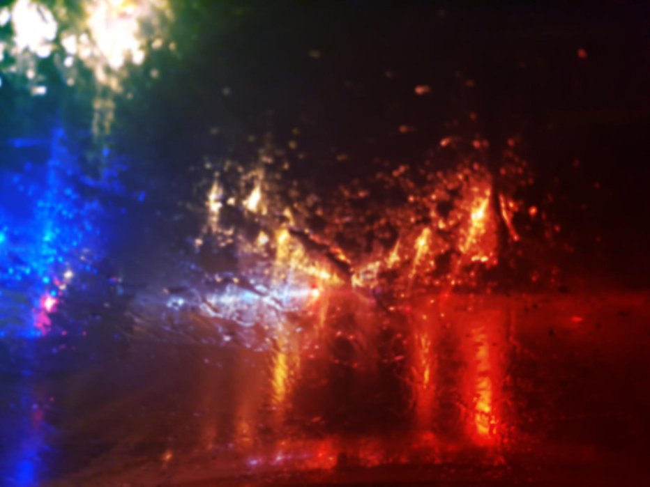 Fotografija: view from car on raindrops on window and road with police lights and silhouettes of cars driving behind him in rainy evening FOTO: Sommersby Getty Images/istockphoto