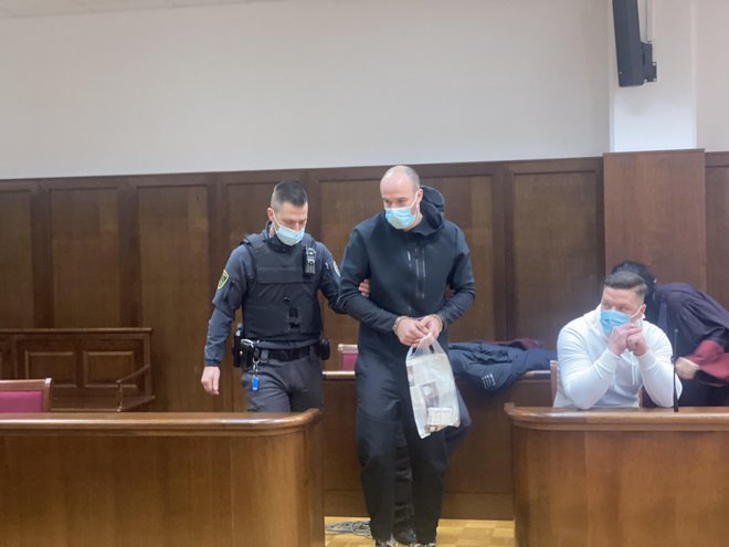 Bojan Stanojević (z vrečko v rokah), na njegovi levi sedi obtoženi Dragan Čikojević. FOTO: PU Koper