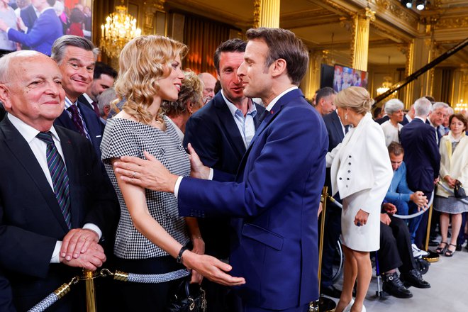 Tiphaine Auziere, hči francoske prve dame Brigitte Macron, med slovesnostjo v Elizejski palači pozdravlja francoskega predsednika Emmanuela Macrona, ko ta po ponovni izvolitvi priseže za drugi predsedniški mandat. FOTO: Gonzalo Fuentes Reuters