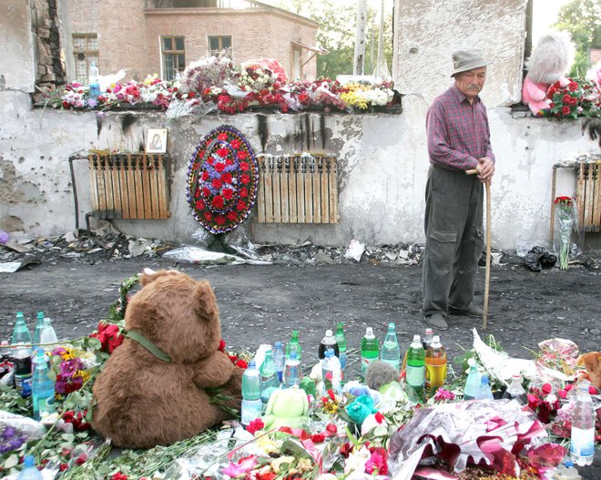 Sorodnik pobitih talcev pred šolsko telovadnico v Beslanu leta 2004. FOTO: Gleb Garanich, Reuters Pictures