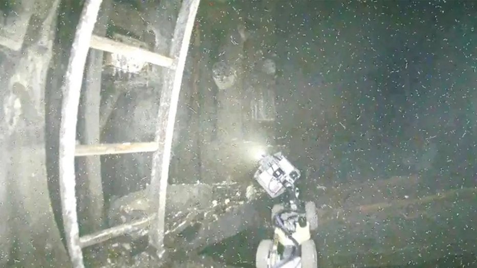Fotografija: Posnetek, na katerem se vidi razdejanje pod reaktorjem in robotsko kačo, ki je pomagala podvodnemu dronu. FOTO: TEPCO