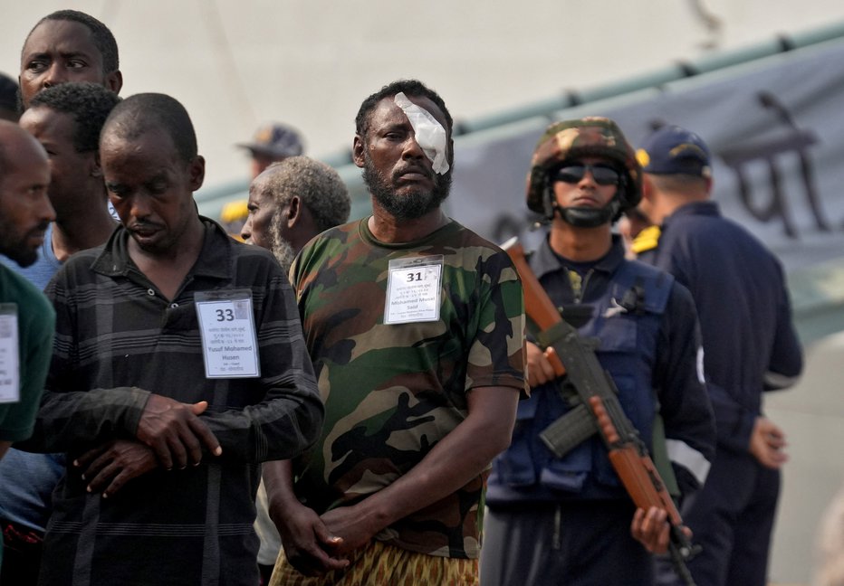 Fotografija: Indijski vojaki z ujetimi somalijskimi pirati na pomolu v indijskem pristanišču Mumbaj. FOTO: Hemanshi Kamani/Reuters
