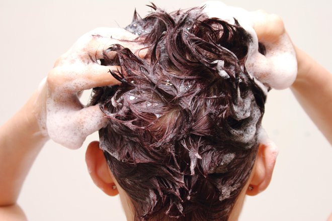 Šampon nežno vmasiramo v lasišče, ko ga bomo spirali, bomo očistili lase po vsej dolžini. FOTO: Tihis/Getty Images
